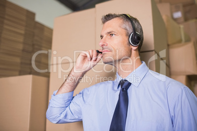 Businessman using headset in warehouse