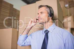 Businessman using headset in warehouse