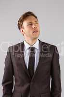 Young businessman thinking and looking up