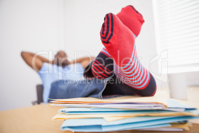 Relaxed businessman with legs on desk in office