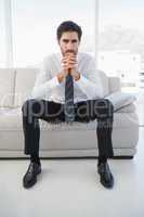 Serious businessman sitting on couch