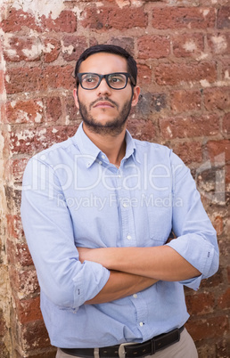 Thoughtful businessman against brick wall