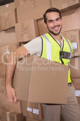 Worker carrying box in warehouse