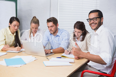 Business man smiling at camera giving thumbs up