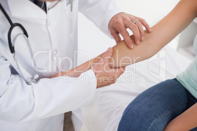 Doctor examining patients arm