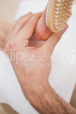Pedicurist brushing customers foot