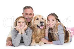 Portrait of happy family lying on the floor with their dog
