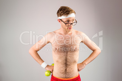 Geeky shirtless hipster posing with dumbbell