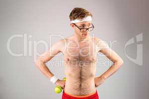 Geeky shirtless hipster posing with dumbbell