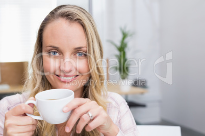 Businesswoman holding coffee mug and smiling