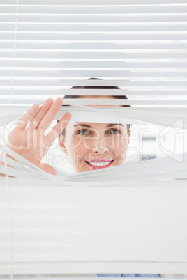 Woman looking out through blinds
