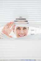 Woman looking out through blinds