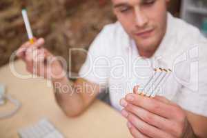 Man deciding between electronic or normal cigarettes