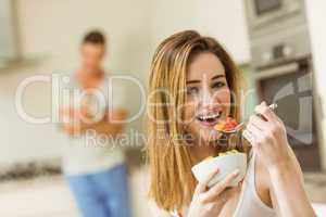 Woman eating fruit salad at breakfast