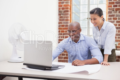 Casual business team using laptop at desk