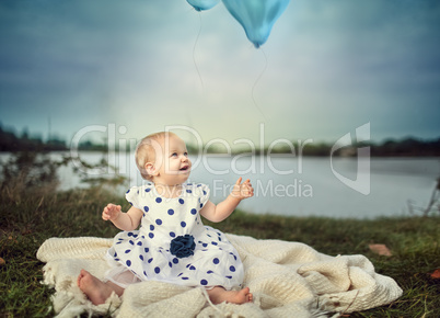 Baby am See mit Luftballon