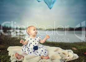 Baby am See mit Luftballon
