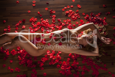 Frau liegt auf dem Boden mit Rosenblüten