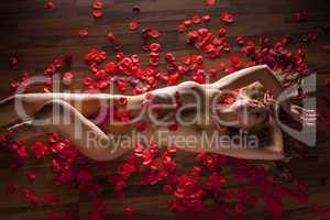 Frau liegt auf dem Boden mit Rosenblüten