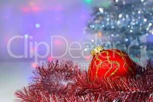 Red Christmas ball under the tree and tinsel
