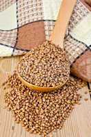 Buckwheat in spoon on board with napkin