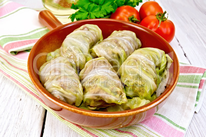 Cabbage stuffed and carrots in ceramic pan on board