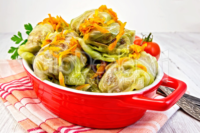 Cabbage stuffed and carrots in pan on board