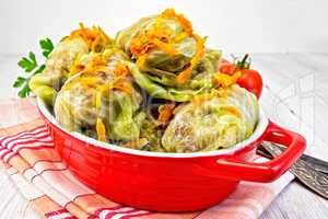 Cabbage stuffed and carrots in pan on board