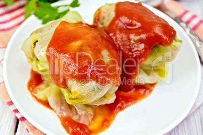 Cabbage stuffed and tomato sauce in plate on board