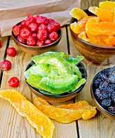 Candied pomelo and berries in bowl on board