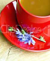 Chicory drink in red cup and flower on board