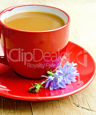 Chicory drink in red cup with flower on saucer