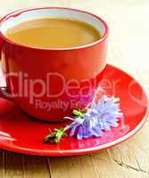 Chicory drink in red cup with flower on saucer