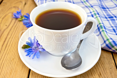 Chicory drink in white cup with flower and napkin on board