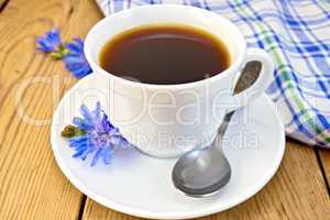 Chicory drink in white cup with flower and napkin on board