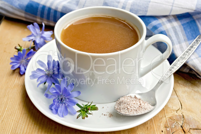 Chicory drink in white cup with flower and spoon on board