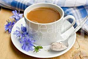 Chicory drink in white cup with flower and spoon on board