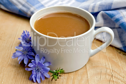 Chicory drink in white cup with flower on board