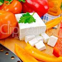 Feta with vegetables and herbs on wooden board