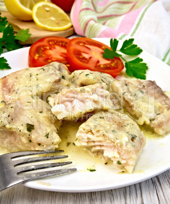 Fish stew in creamy sauce with tomatoes in plate on board