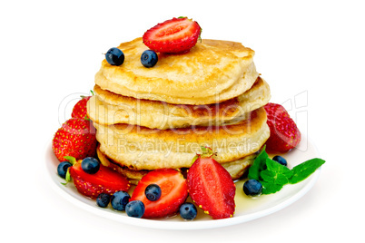 Flapjacks with strawberries and blueberries in plate