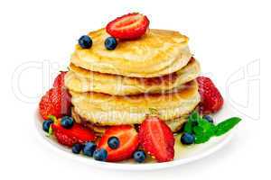 Flapjacks with strawberries and blueberries in plate