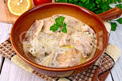 Fish stew in sauce on ceramic pan