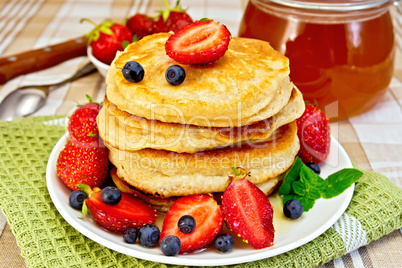 Flapjacks with strawberries and blueberries on napkin