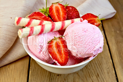 Ice cream strawberry in bowl with wafer rolls on board