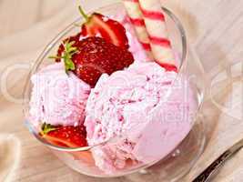 Ice cream strawberry in glass bowl with waffles on fabric