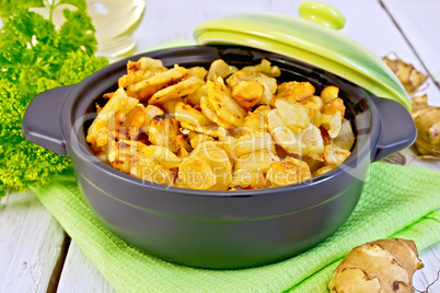 Jerusalem artichokes roasted in pan with lid on light board