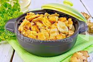 Jerusalem artichokes roasted in pan with lid on light board
