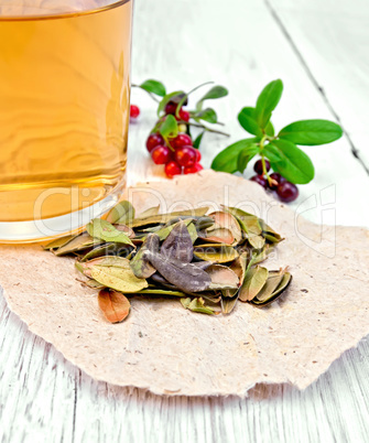 Lingonberry leaf on paper with tea in mug