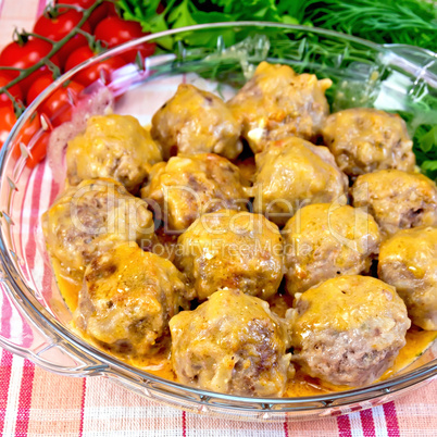 Meatballs with sauce in glass pan on fabric